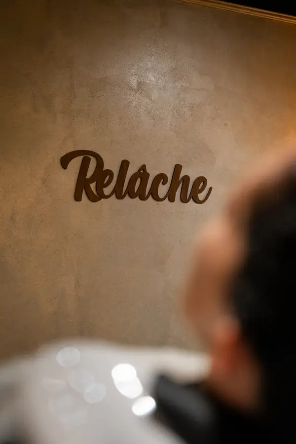 Enseigne "Relâche" sur mur texturé, personne floue au premier plan — Lucas Gouritin