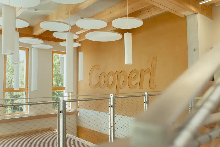 Intérieur lumineux d'entreprise avec logo Cooperl, poutres bois et design moderne — Lucas Gouritin
