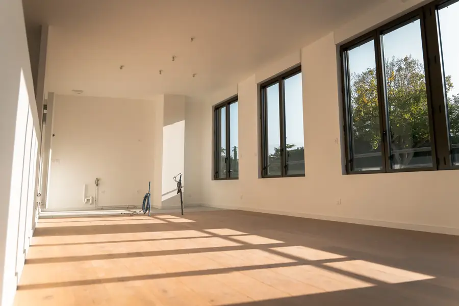 Pièce vide lumineuse avec parquet et fenêtres pour aménagement corporate — Lucas Gouritin